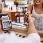 a woman pays for coffee with a credit card.