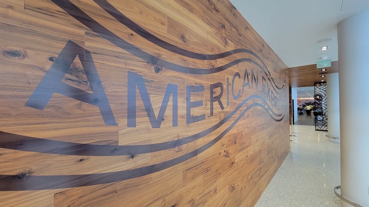 A large wood-paneled wall with American Express branding outside an Amex Centurion Lounge.