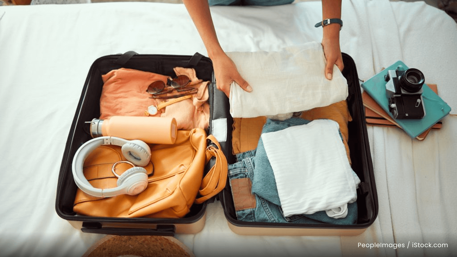 A person packing their carry on luggage.