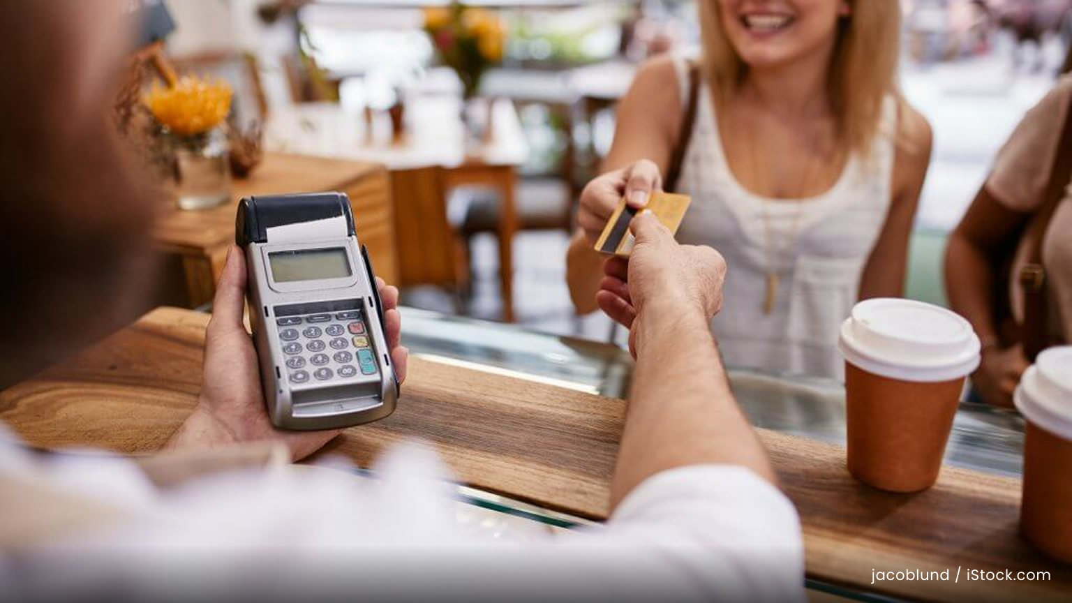 a woman pays for coffee with a credit card.