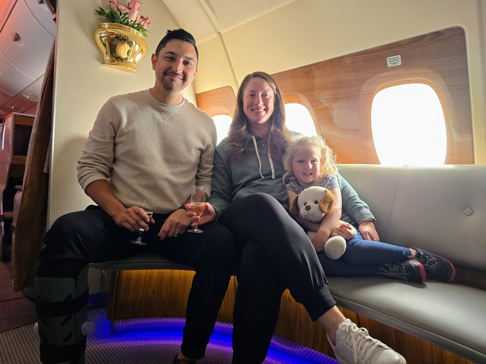 The author and family sitting on a sofa in the Emirates Airbus A380 onboard business class bar/lounge.