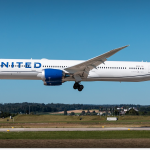 A United Airlines Boeing 787 about to land on a runway with a rural area and blue sky in the background.