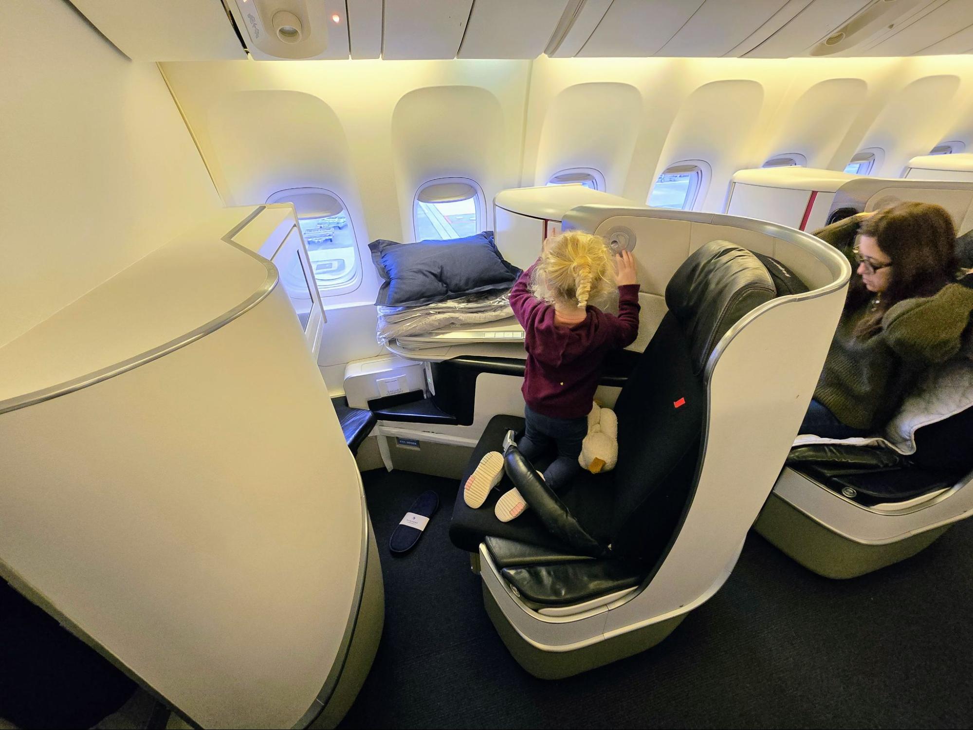Author Joseph Hostetler's young child kneeling on the seat in Air France business class.
